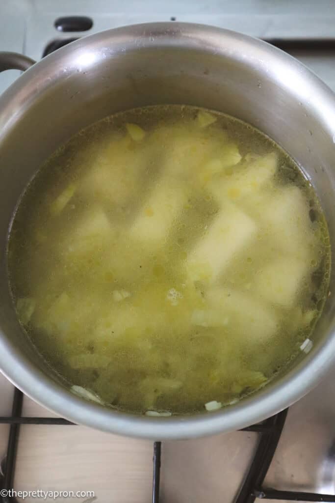celery, potatoes, onion and garlic with water cooking in pot