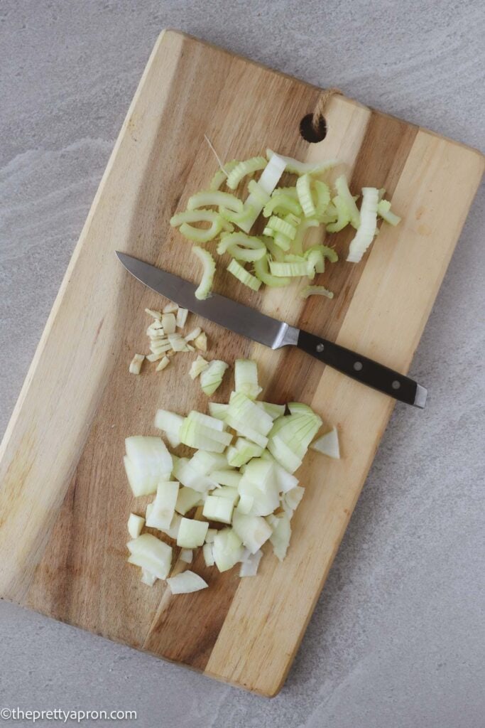chopped celery, garlic and oinion on wooden board