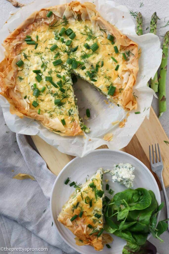 asparagus ricotta quiche with phyllo dough with slice on plate with salad and ricotta dip