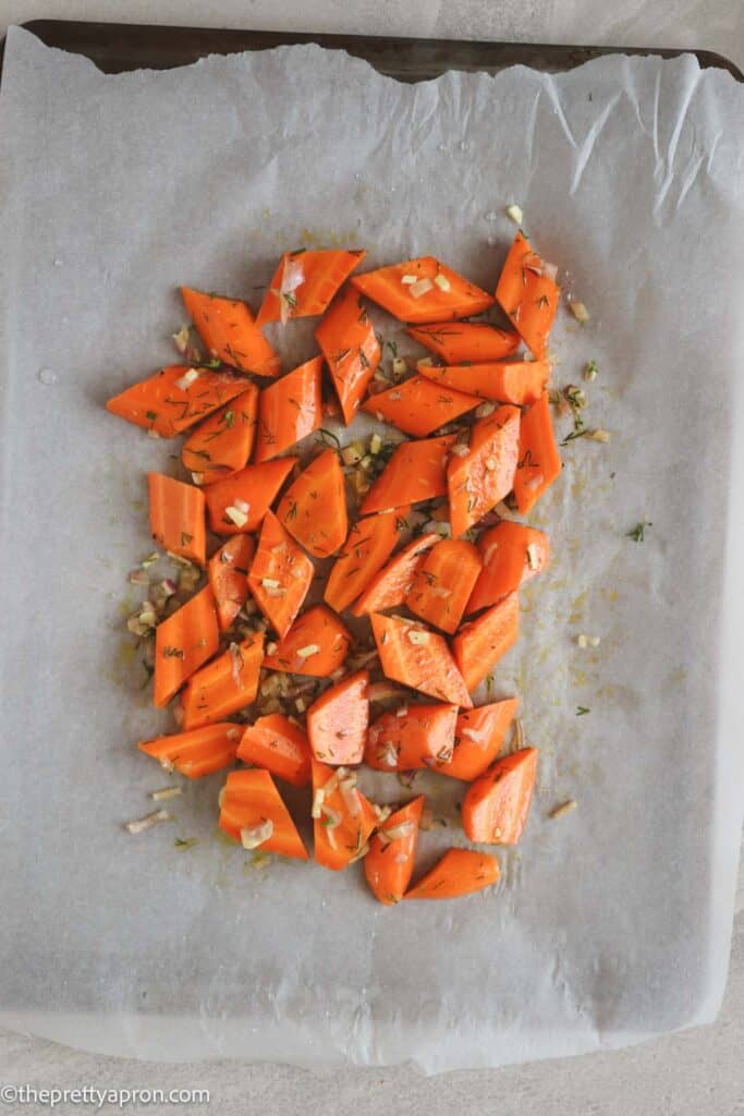chopped carrots spread on parchment paper on baking sheet