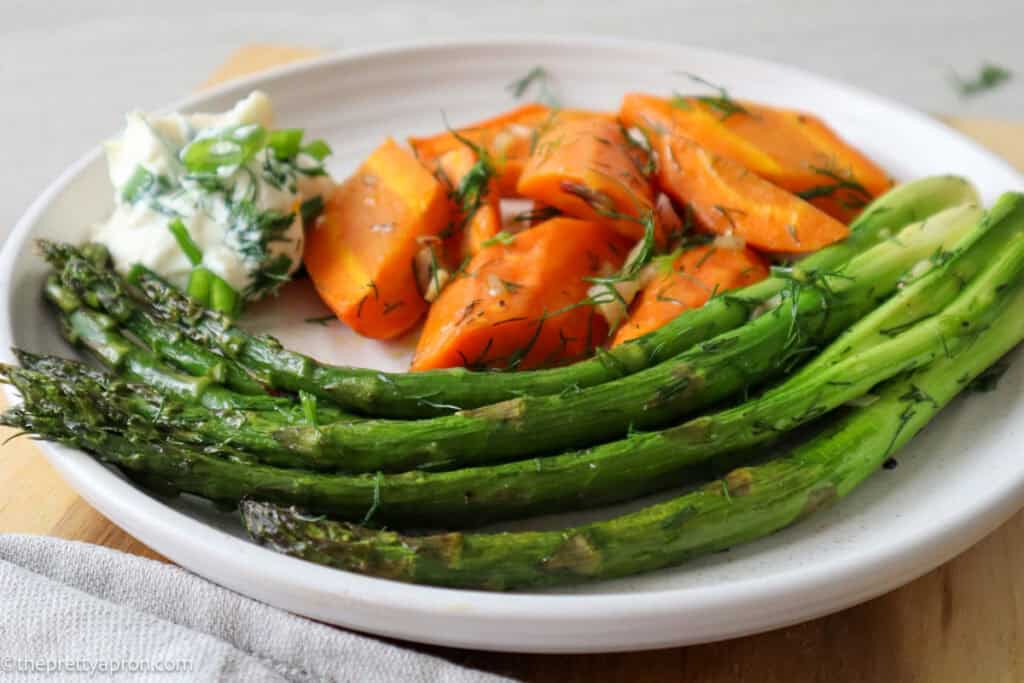 Roasted asparagus and carrots on beige plate with whipped ricotta dip