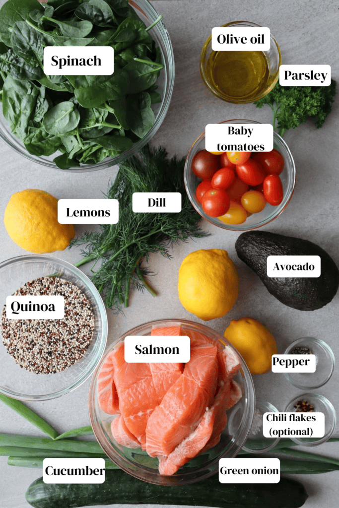 salmon quinoa salad ingredients labelled spinach, quinoa, tomatoes, lemons, sping onion, olive oil