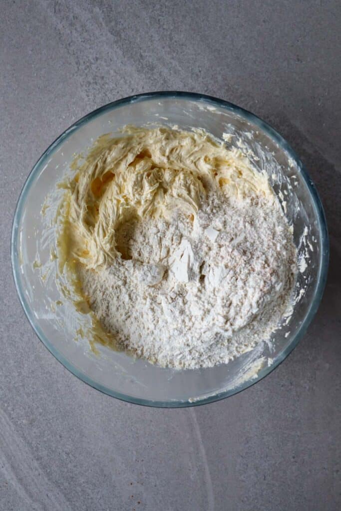 flour added to creamed eggs, butter and sugar in glass bowl