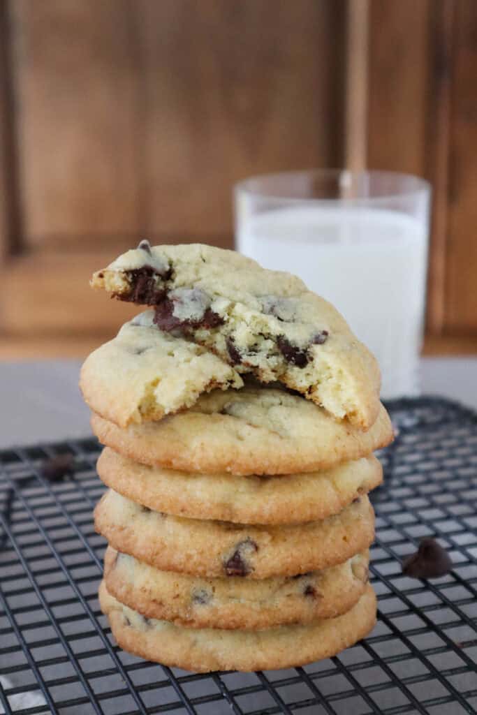 Stack of chocolate chip cookies made without brown sugar with glass of milk