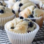 Close up of four Blueberry and cottage cheese muffins on a cooling rack.