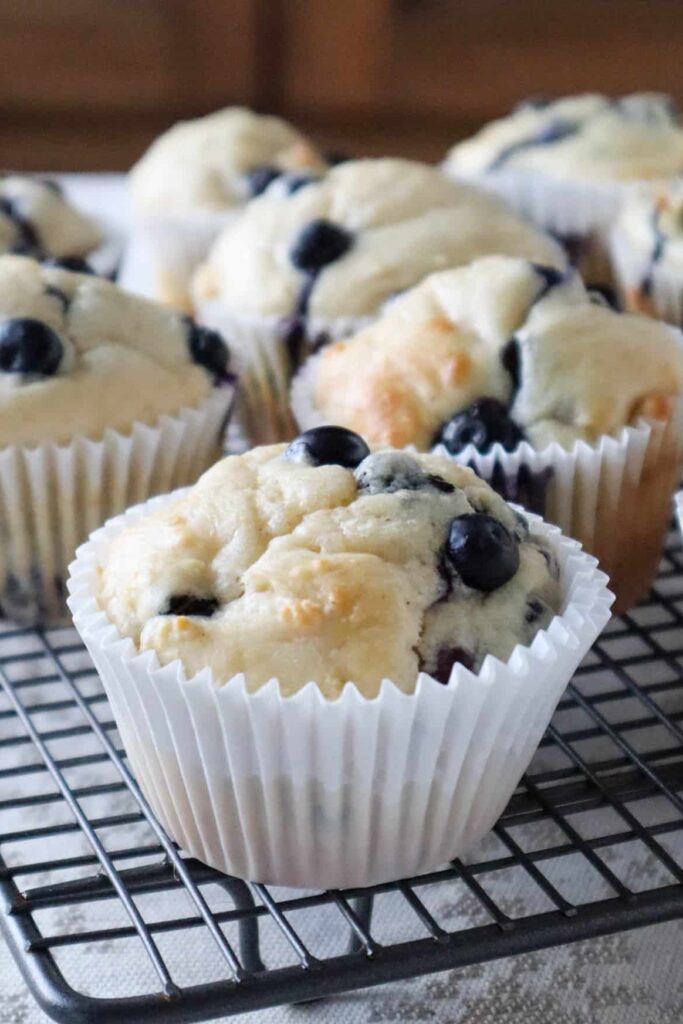 Close up of four Blueberry and cottage cheese muffins on a cooling rack.