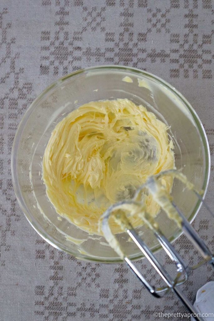 Whipped butter in glass bowl with hand held mixer showing.