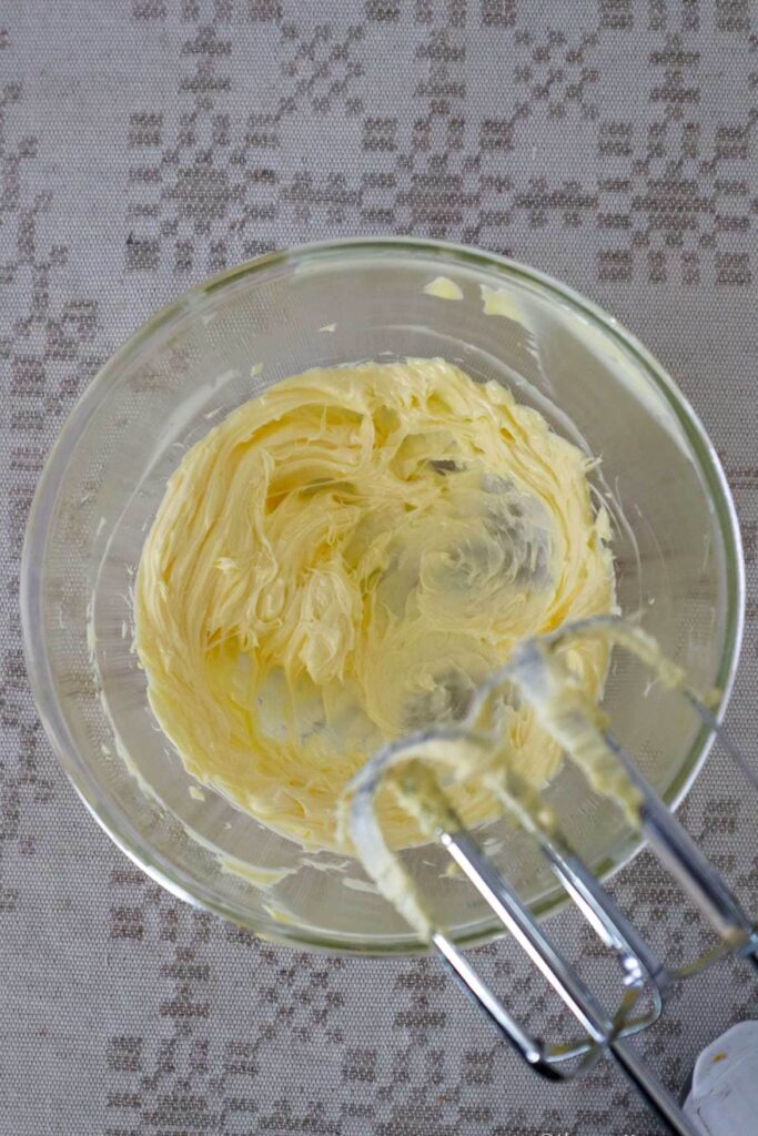 Whipped butter in glass bowl with hand held mixer showing.