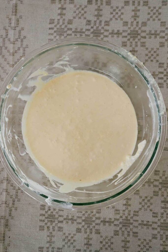 Muffin batter in a glass bowl on a linen tablecloth