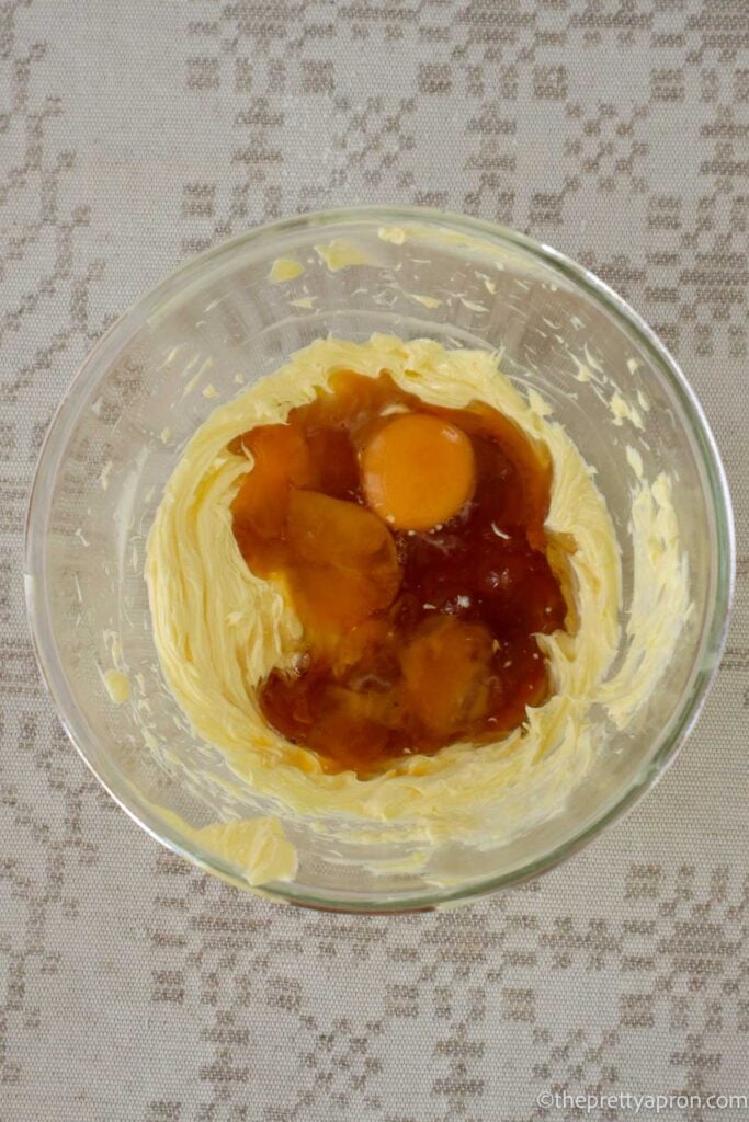 Whipped butter in glass bowl and two egg yolks and maple syrup added.