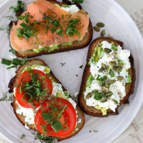 Trio of cottage cheese avocado toast with tomato, smoked salmon and seeds