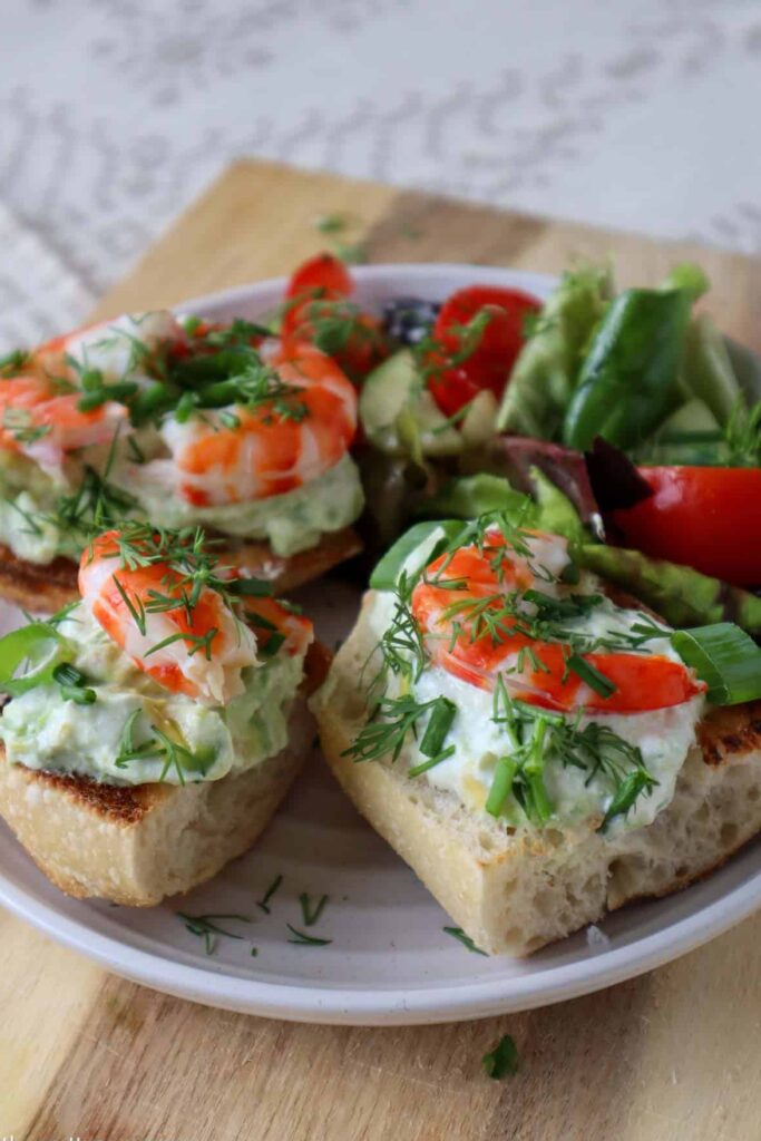 shrimp and avocado toast on plate with garden salad