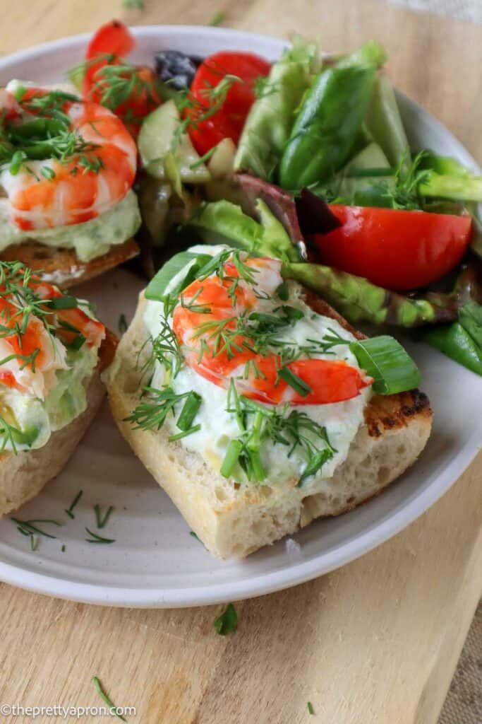 shrimp avocado toast on plate with garden salad