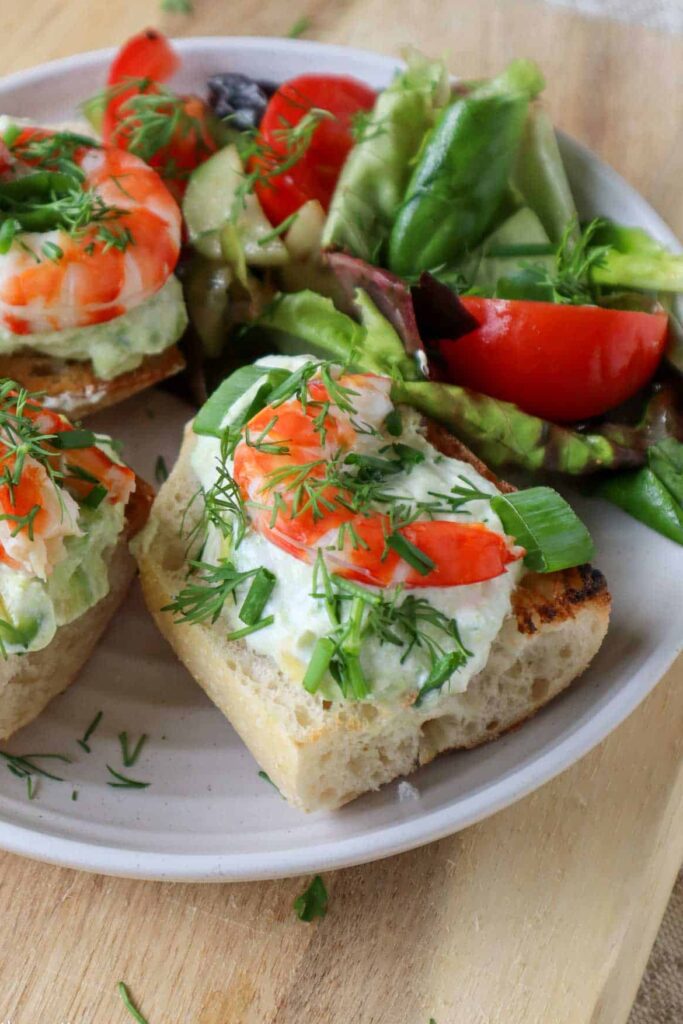 shrimp avocado toast on plate with garden salad
