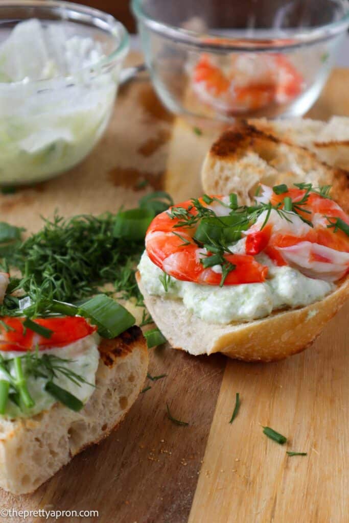 shrimp avocado toast on wooden board with herbs