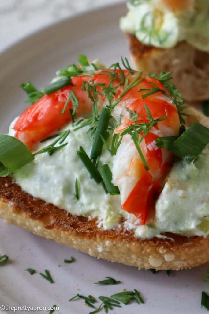 close up of shrimp and avocado toast with dill and chives