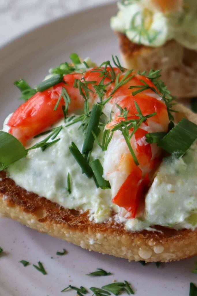 close up of shrimp and avocado toast with dill and chives