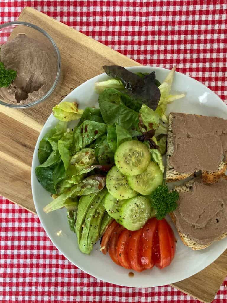 Chicken liver pâté on bread with green salad, cucumbers, tomatoes and avocado.