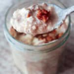 spoonful of creamy cinnamon roll overnight oats with pecan taken from glass jar.