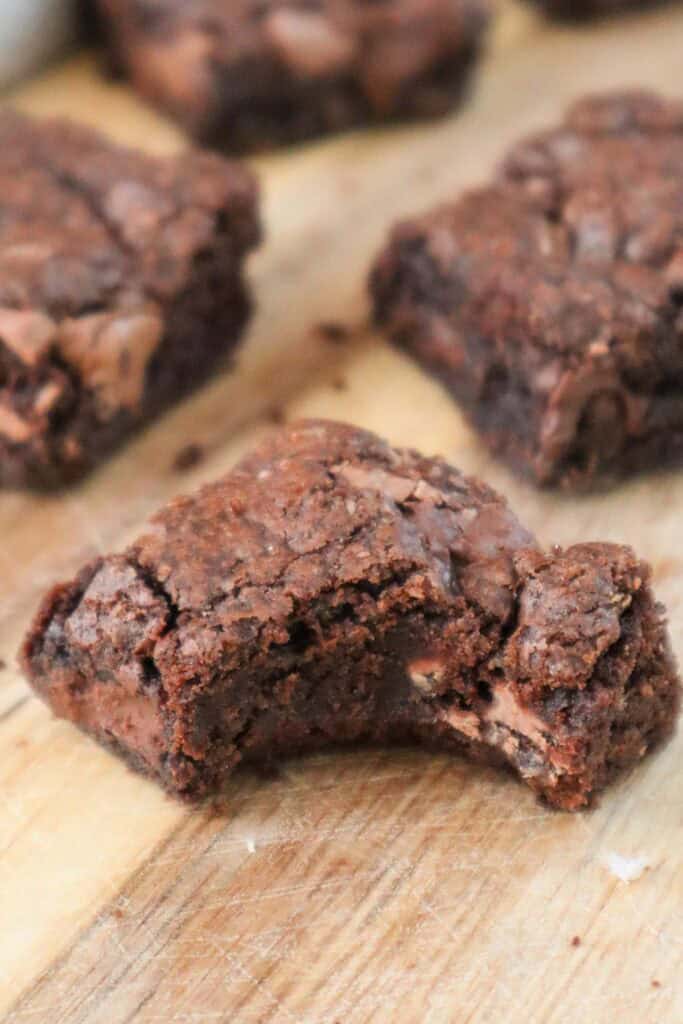 Three chocolate chocolate chip cookie bars woth one of them having a bite taken out of it.