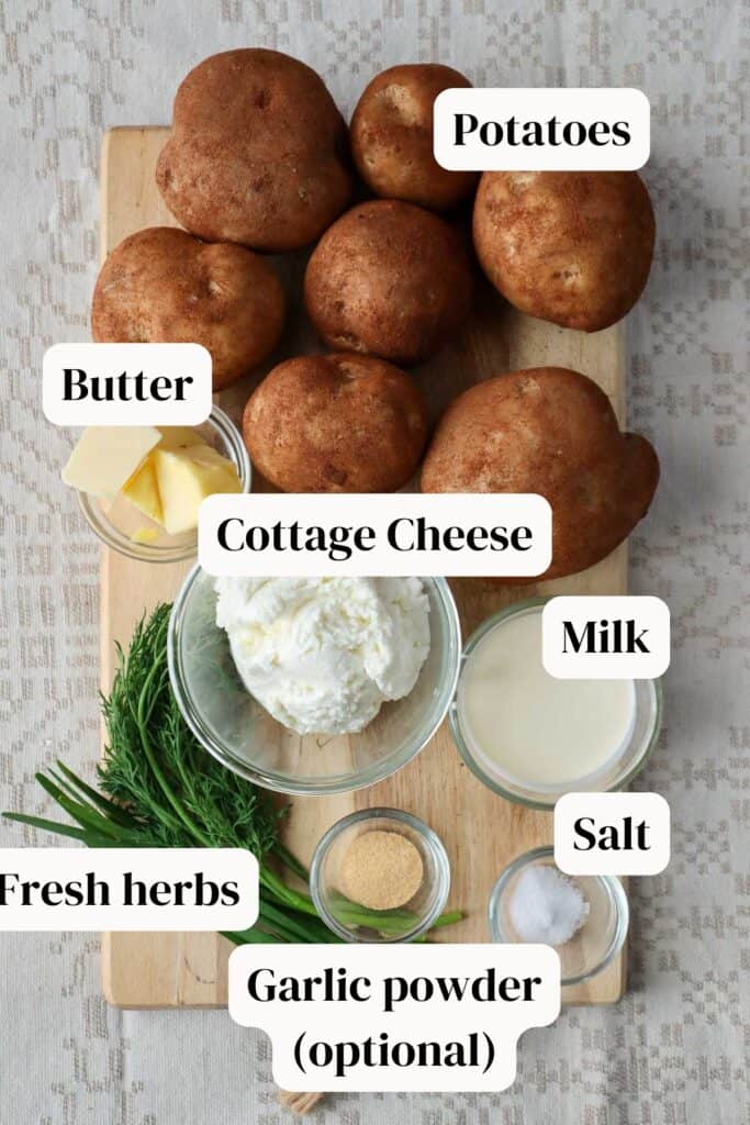 Potatoes, cottage cheese, butter, dill, chives, garlic powder, salt on wooden board.