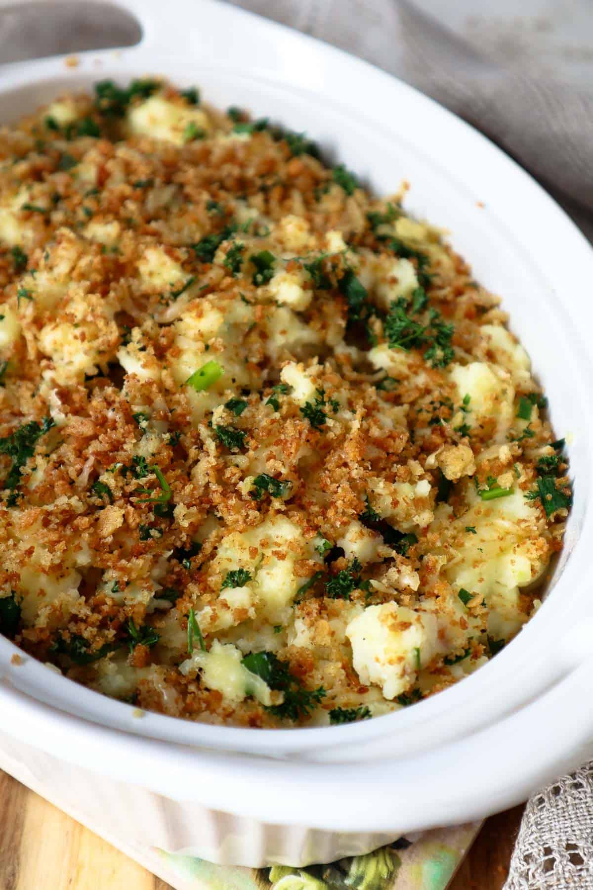 Cottage cheese mashed potatoes topped with crispy panko crumbs topping in beige dish.