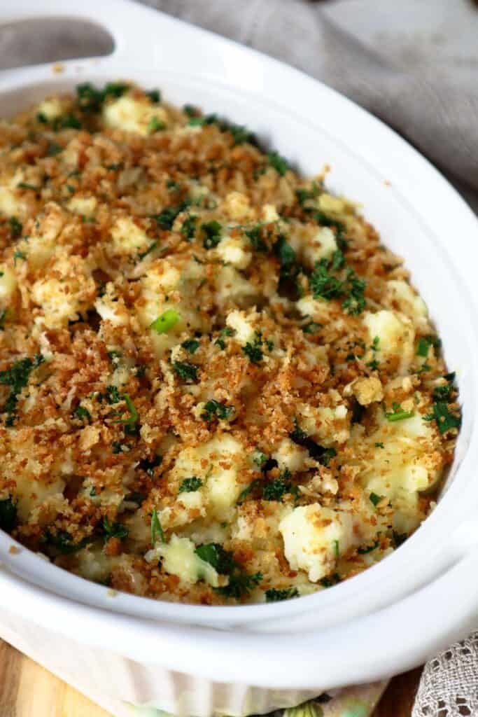 Cottage cheese mashed potatoes topped with crispy panko crumbs topping in beige dish.