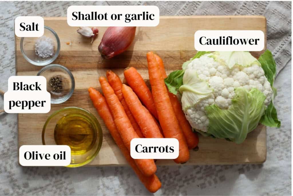 Cauliflwoer, carrots, shallot, garlic, olive oil, salt, pepper on wooden board.