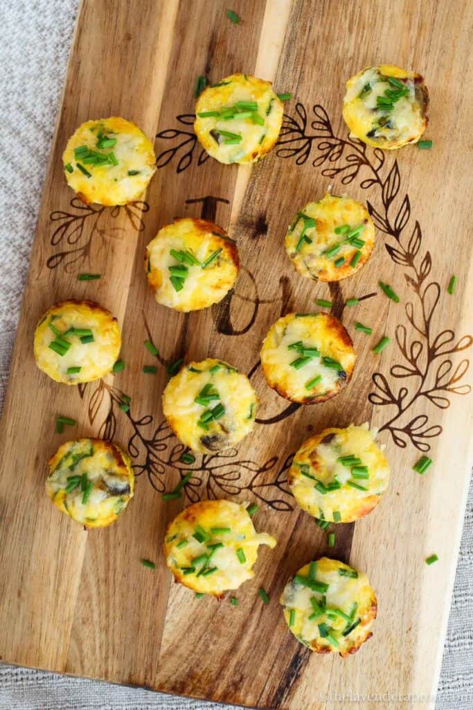 Bacon and mushroom mini quiches on wooden board.
