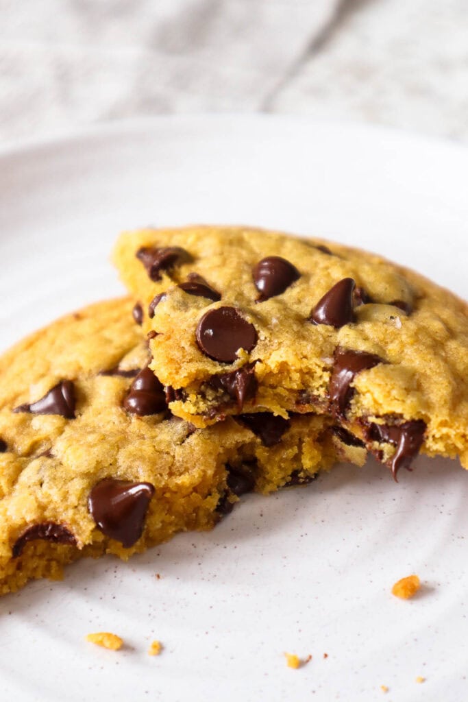 Chocolate chip cookie broken into two pieces and bite taken out of one of them.