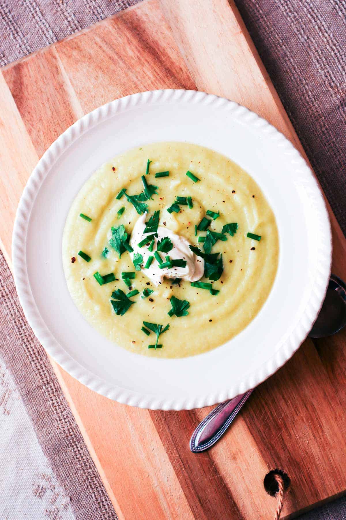 Delicious homemade potato soup garnished with parsley and sour cream, perfect for cozy meals.