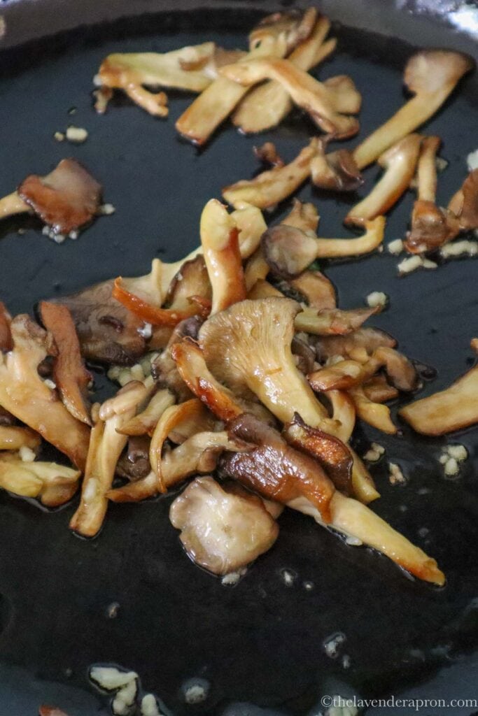 Sautéing minced garlic for a couple minutes with the oyster mushrooms.