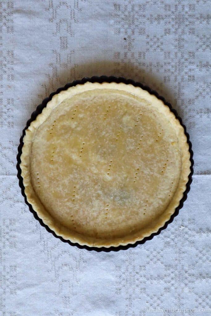 A blind baked pie crust ready to be filled with spinach and salmon.