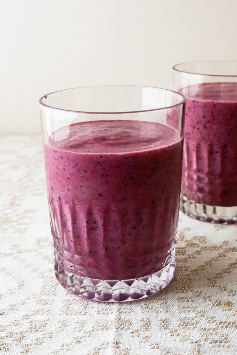 purple pink hemp seed smoothie in a two glasses on a linen tablecloth.