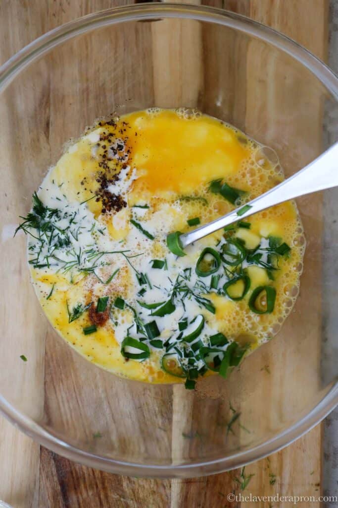 Whisking together the eggs, cream, nutmeg, salt and pepper to make the egg custard for the salmon spinach quiche.
