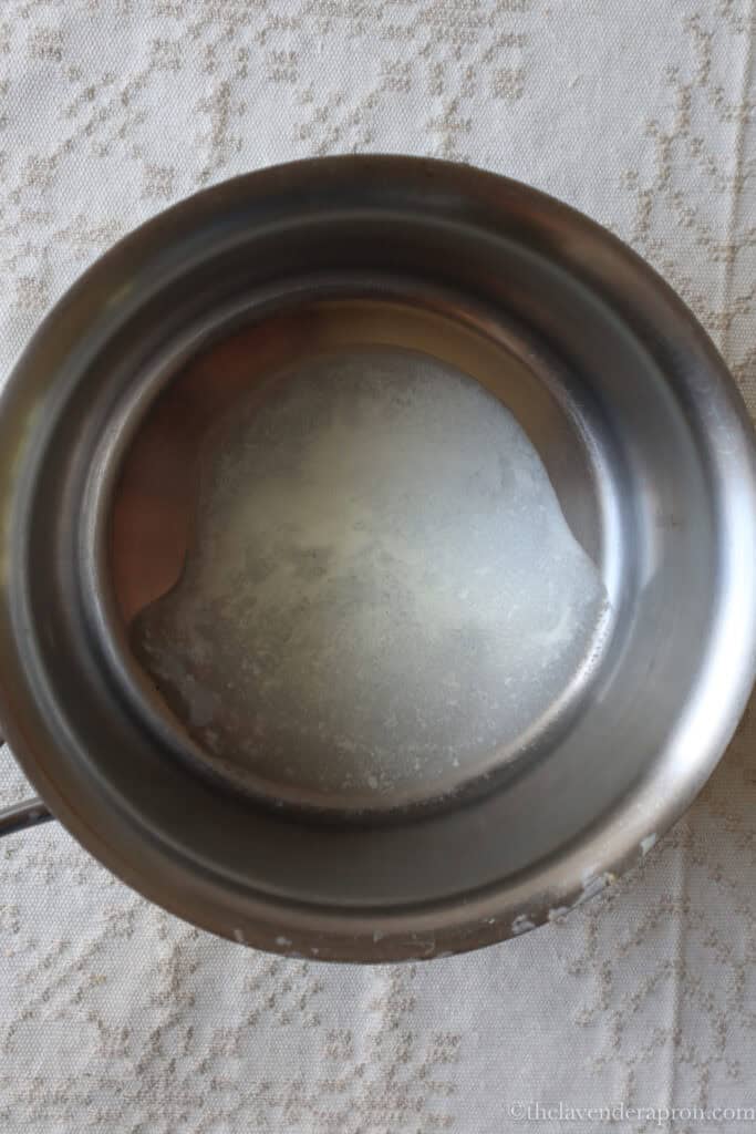 Bowl showing liquid drained from cottage cheese after straining.