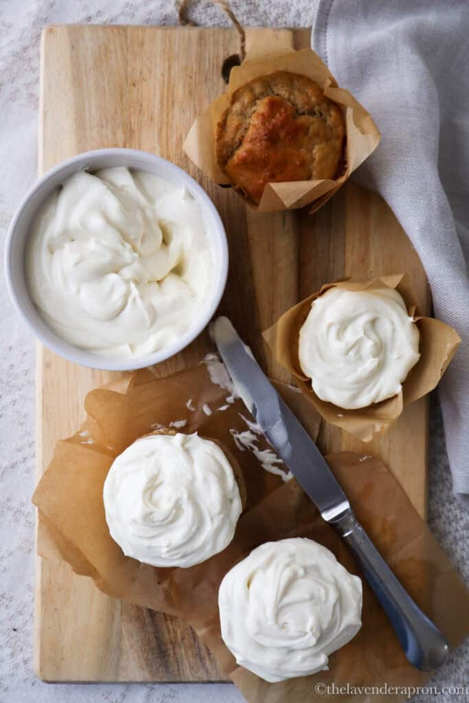 Spreading cottage cheese frosting on a cupcake with a palette knife.