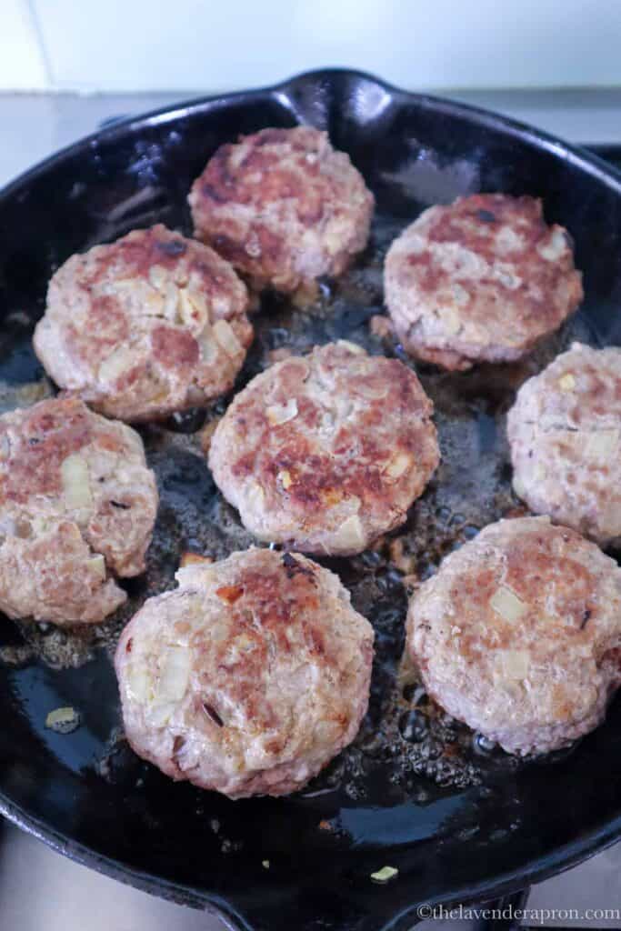 Browning Latvian kotletes in a cast iron pan.