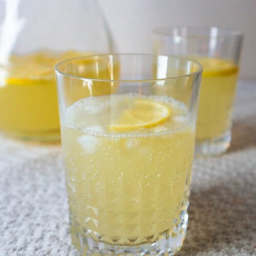 Chamomile honey lemonade served in a glass with a slice of lemon and ice cubes.