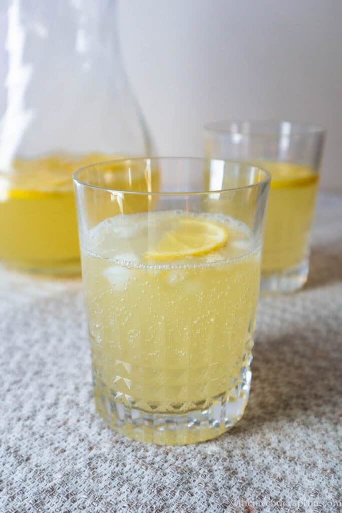 Chamomile honey lemonade served in a glass with a slice of lemon and ice cubes.
