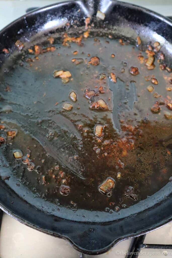 Juices from cooking the kotletes in a black pan.