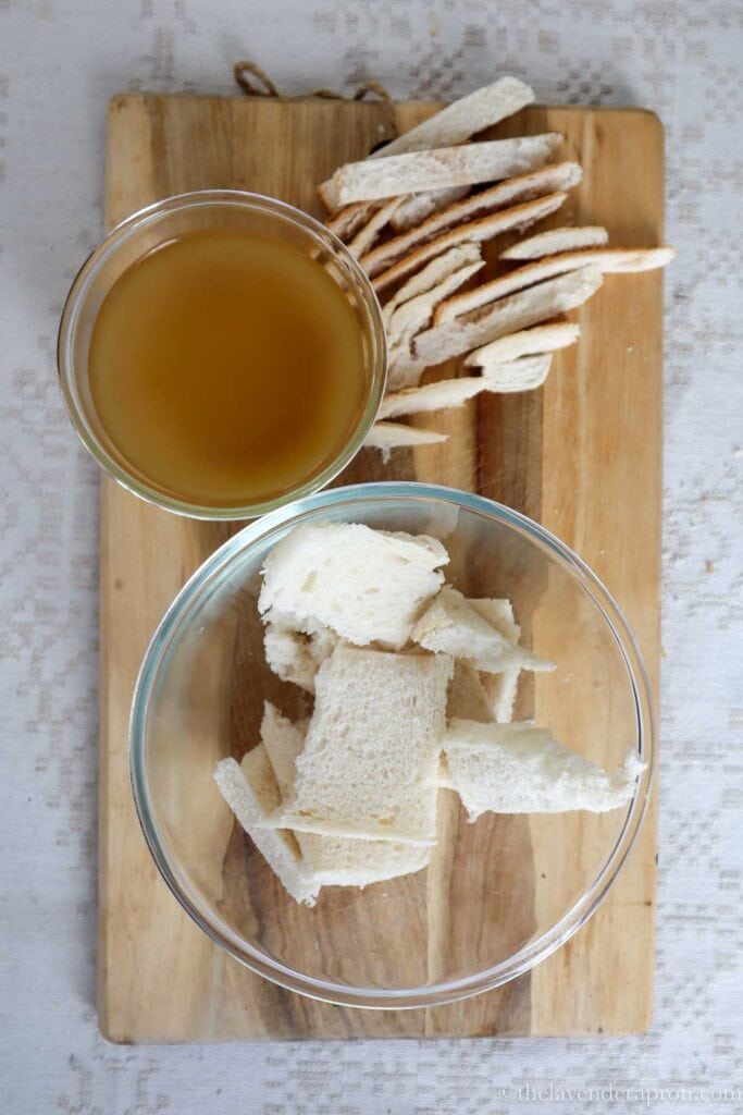 Cutting off the crust of bread and preparing beef bouillon.