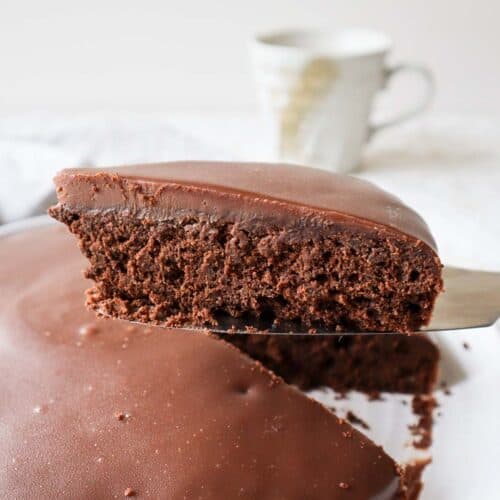 Belgian chocolate cake slice with Belgian chocolate ganache taken out of the whole cake.