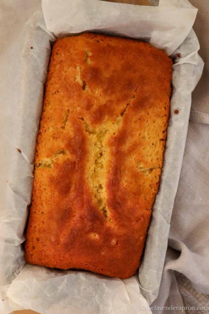 Baked French yogurt cake in a loaf tin showing crack on the top.