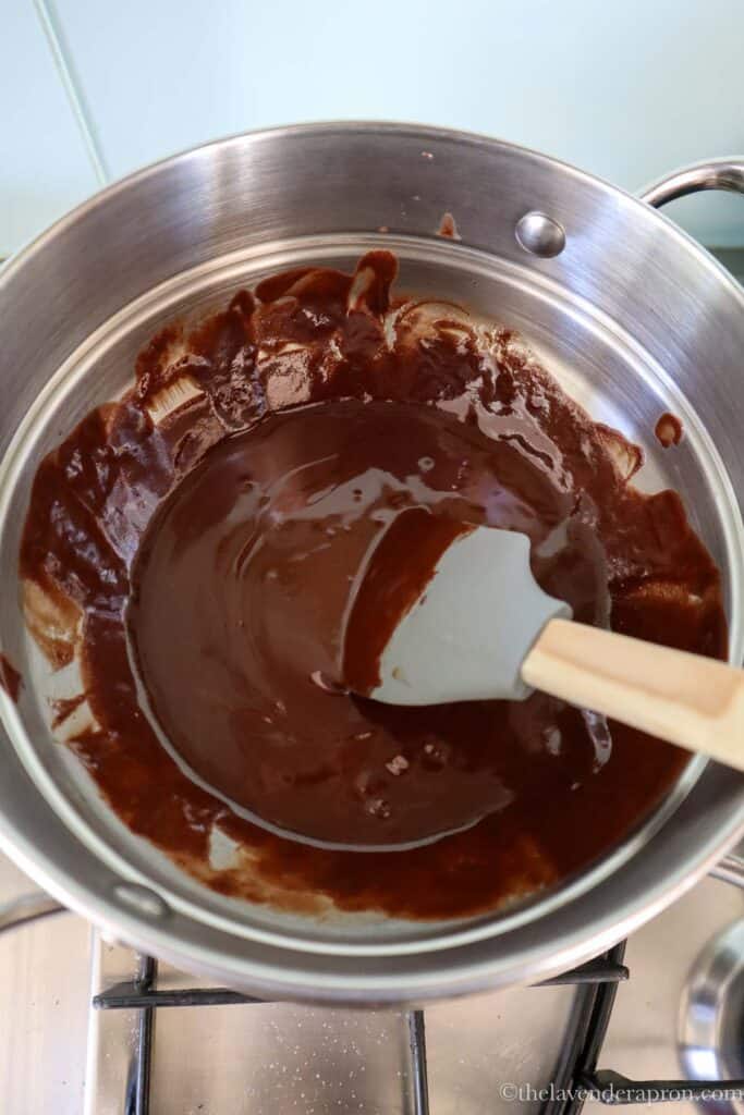 Melting Belgian chocolate and butter in a bowl over simmering water.