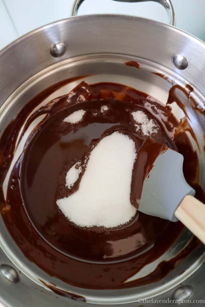 Stirring in the sugar while melted chocolate is still warm.