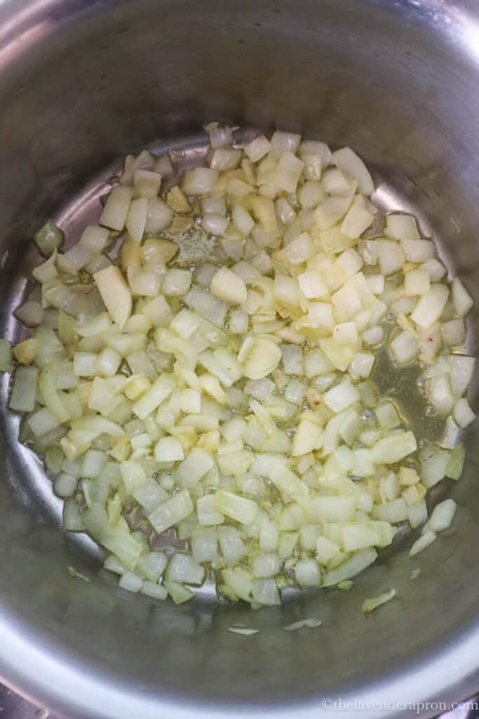 Diced onions and garlic sauteing in a pot.