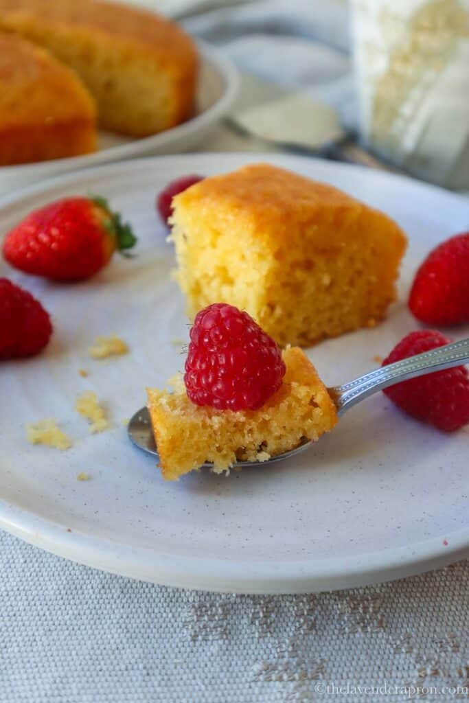Spoonful of French lemon yogurt cake with a fresh raspberry on top.