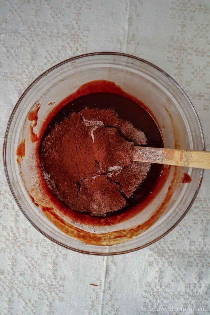 Sifting in the flour, cocoa powder and baking powder into the Belgian chocolate mixture.
