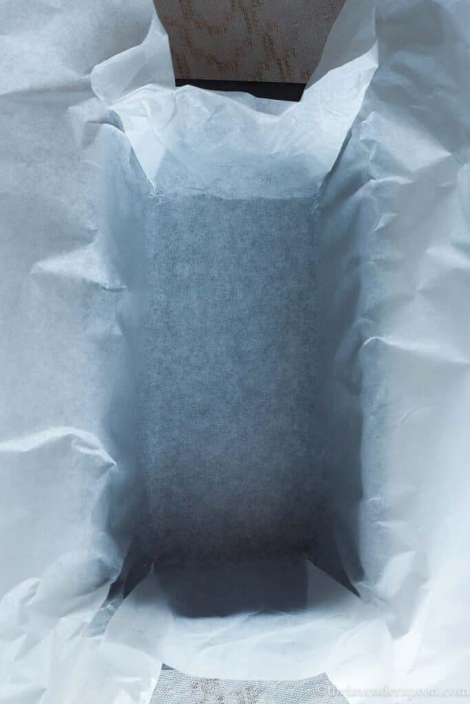 Baking paper lining the inside of a loaf pan.